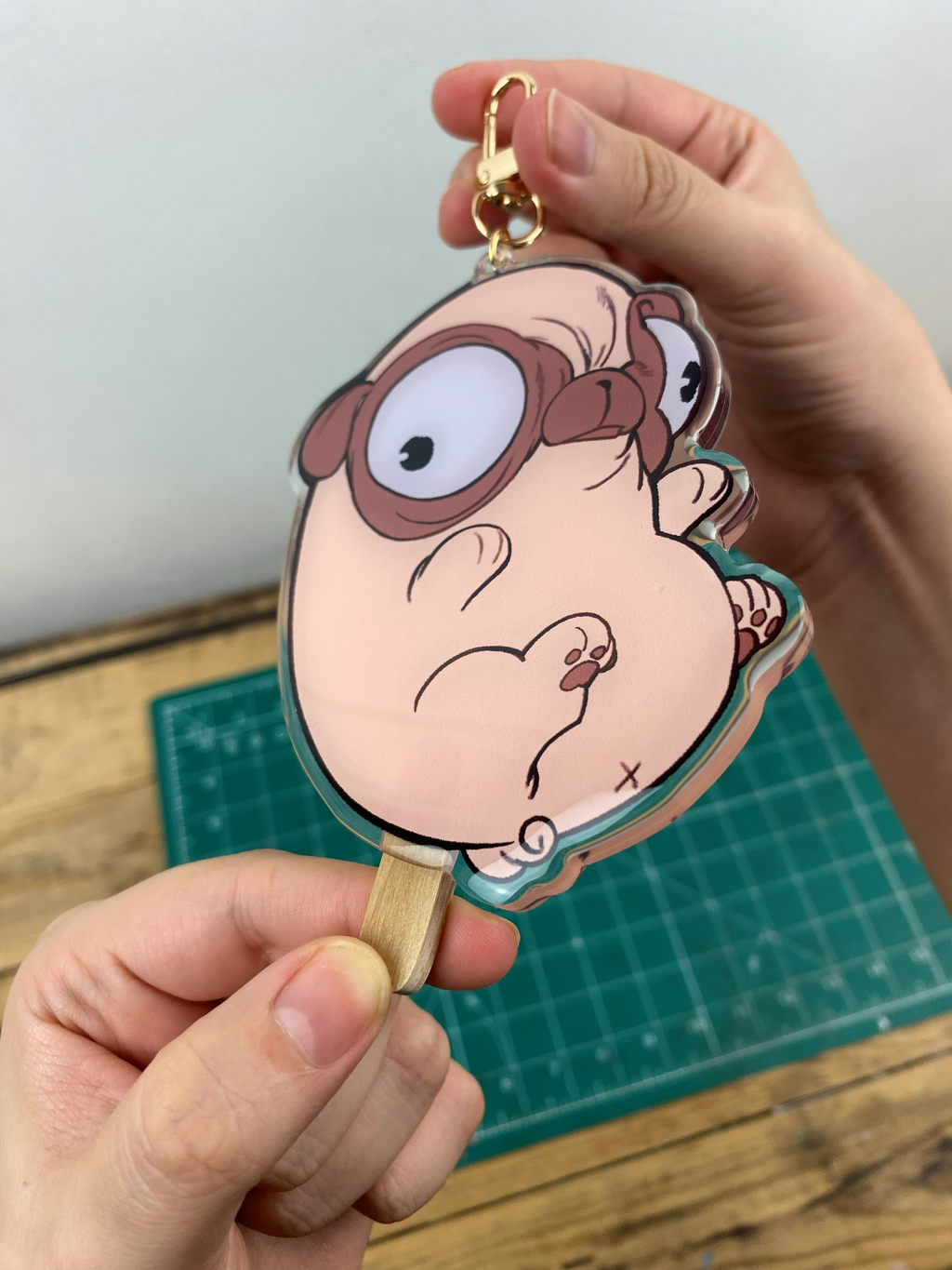 Pug-shaped Keychain that looks like a bean-shaped popsicle.